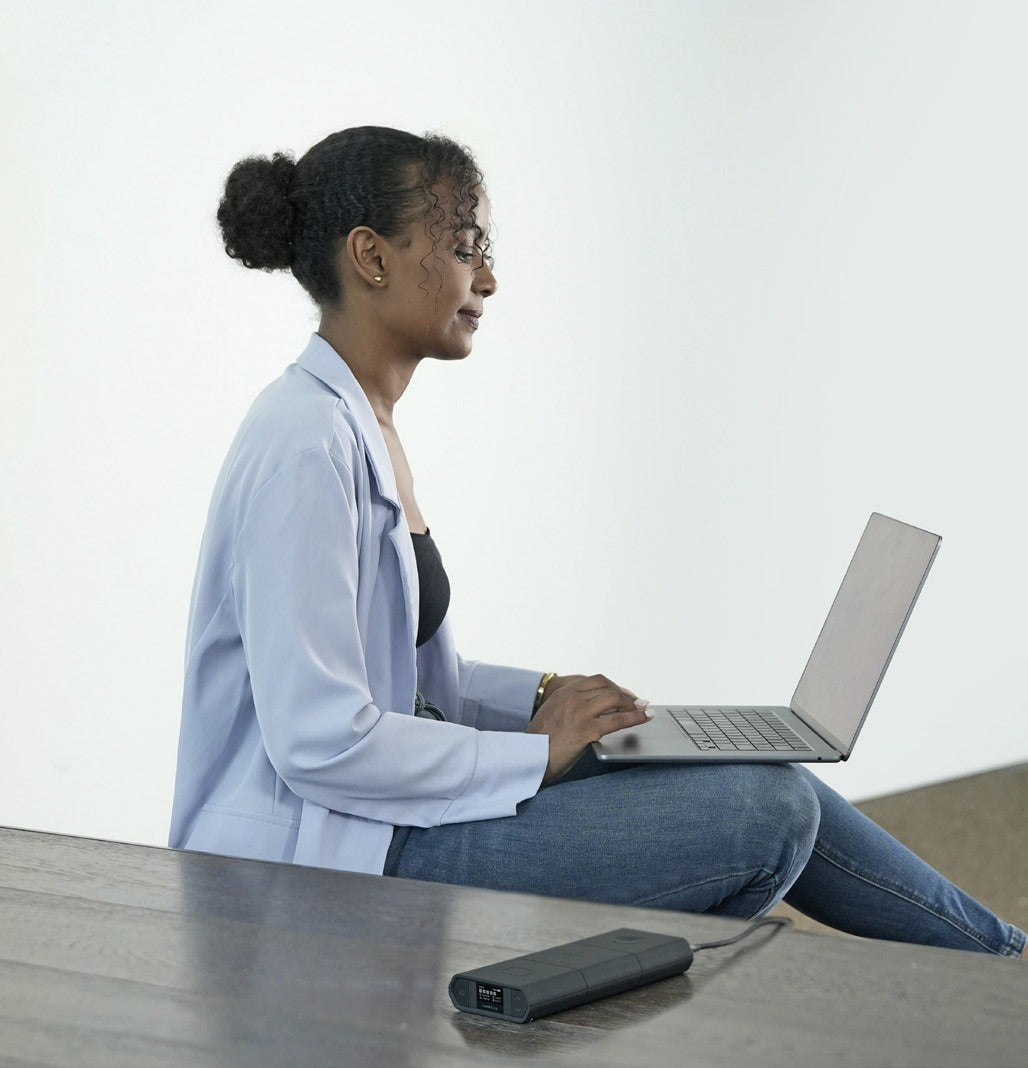 Employee working on a laptop powered by an Omni power bank